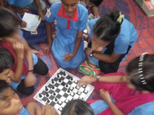 Out of School Children Learners are performing chess.